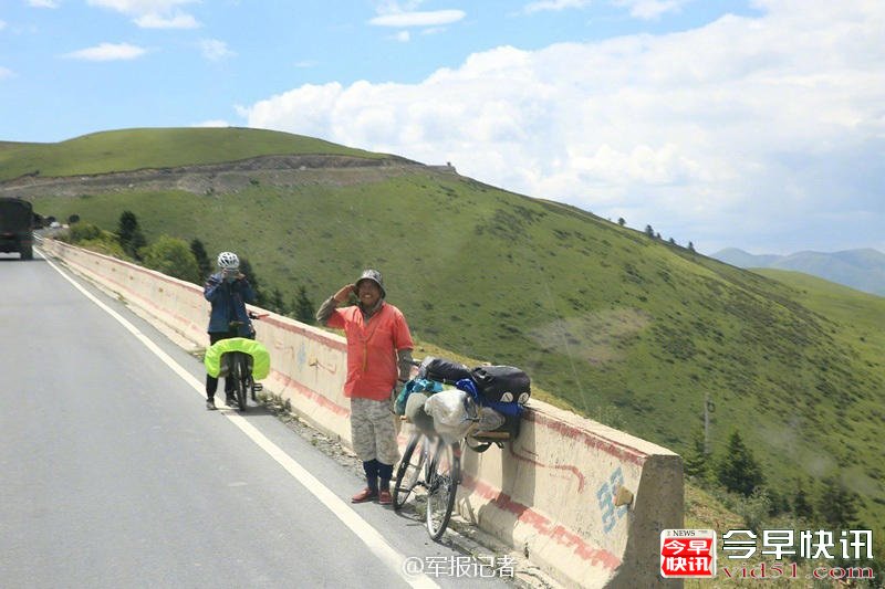 同路上高原的旅友，微笑着向解放军车队敬礼。看这朋友的装备，可能还是位“军迷”。 (来自:军报记者)