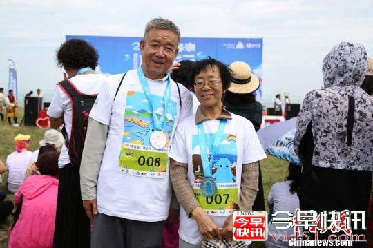 8月19日，160余徒步爱好者健步青海湖，以行走的方式倡议环境保护。图为在本次健步行走中获得奖牌的大龄徒步爱好者。　罗云鹏 摄