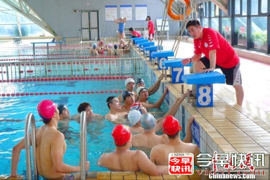 运动员们在游泳池畔向教练讨教动作要领与比赛技术。校方提供
