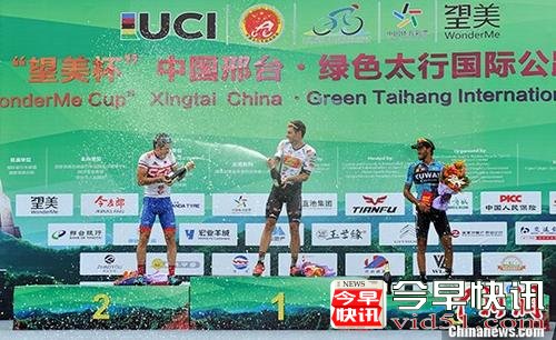 图为本赛段前三名选手上台领奖开香槟庆祝。 中新社记者 韩冰 摄